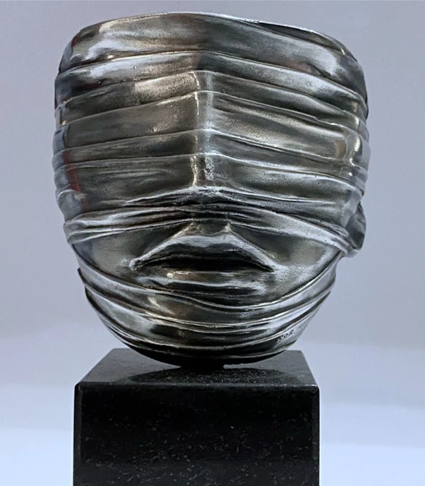 Igor Mitoraj, »Tilsløret ansigt«, 1977 – sølvskinnende skulptur af et ansigt svøbt i bånd, på sort sokkel