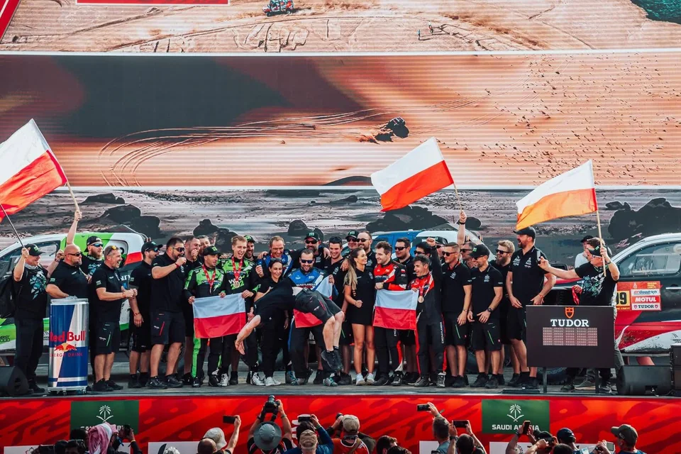 Das Energylandia Rally Team mit polnischen Flaggen auf der Zielrampe der 48. Rallye Dakar in Yanbu