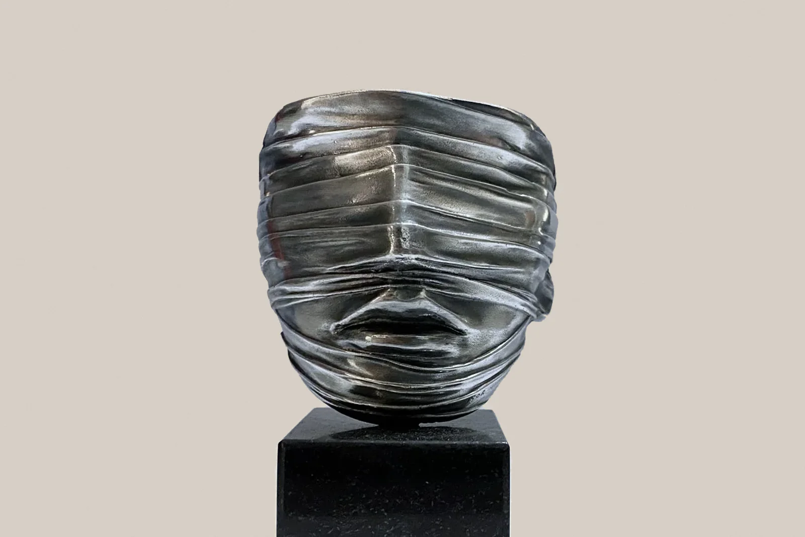 Igor Mitoraj, ‘Veiled Face’, 1977 – silvery sculpture of a face wrapped in bands, on a black base