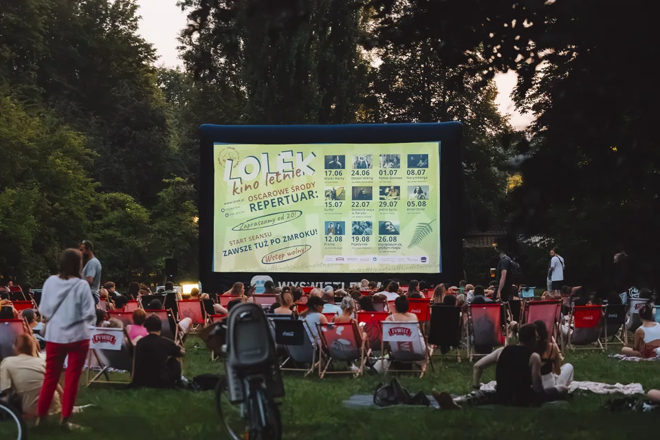 Lærred med programmet for LOLEK Kino Letnie »Oscarowe Środy« og publikum i liggestole